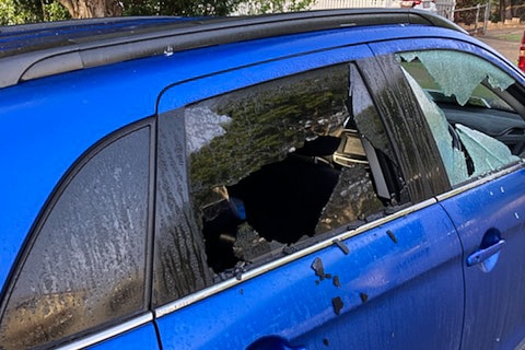 A blue car with smashed windows