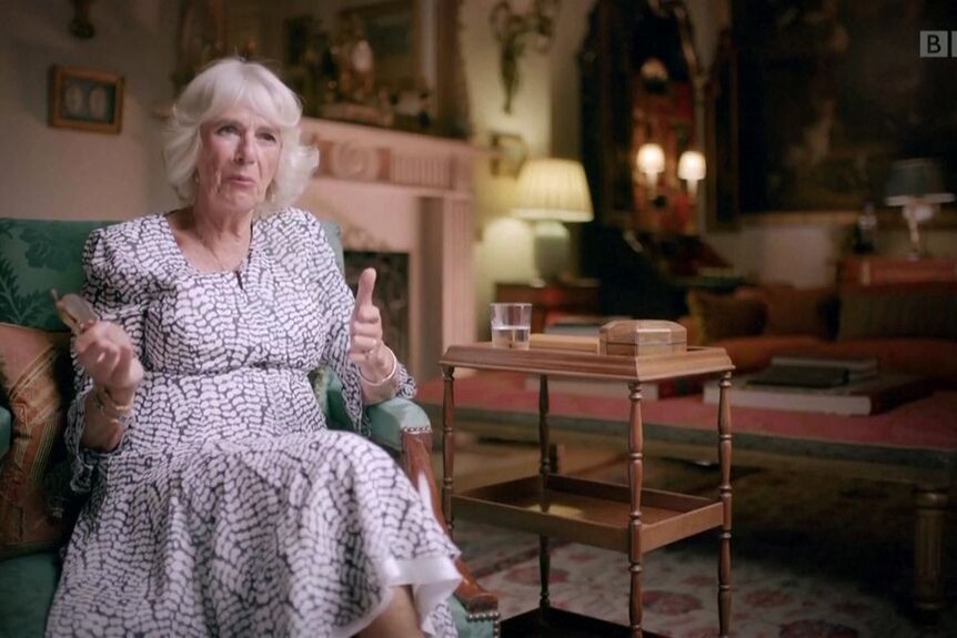 Queen Consort Camilla sitting in a chair speaks to camera