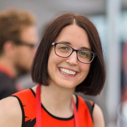 A woman with brown hair smiles at the camera