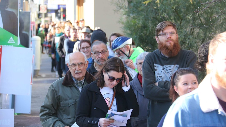 Long line of people waiting in the sun to cast their vote