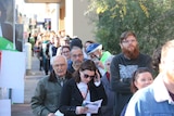 Long line of people waiting in the sun to cast their vote