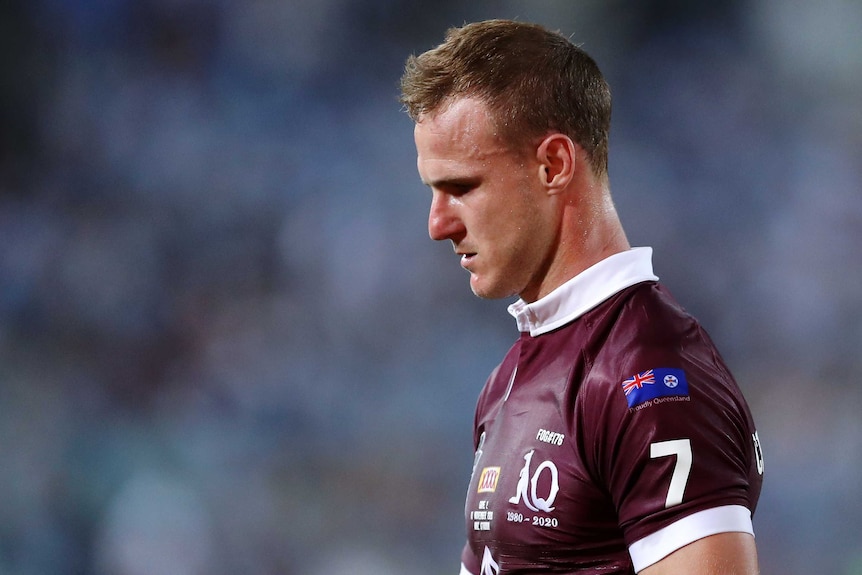 A male Queensland State of Origin player looks down at the ground against New South Wales.