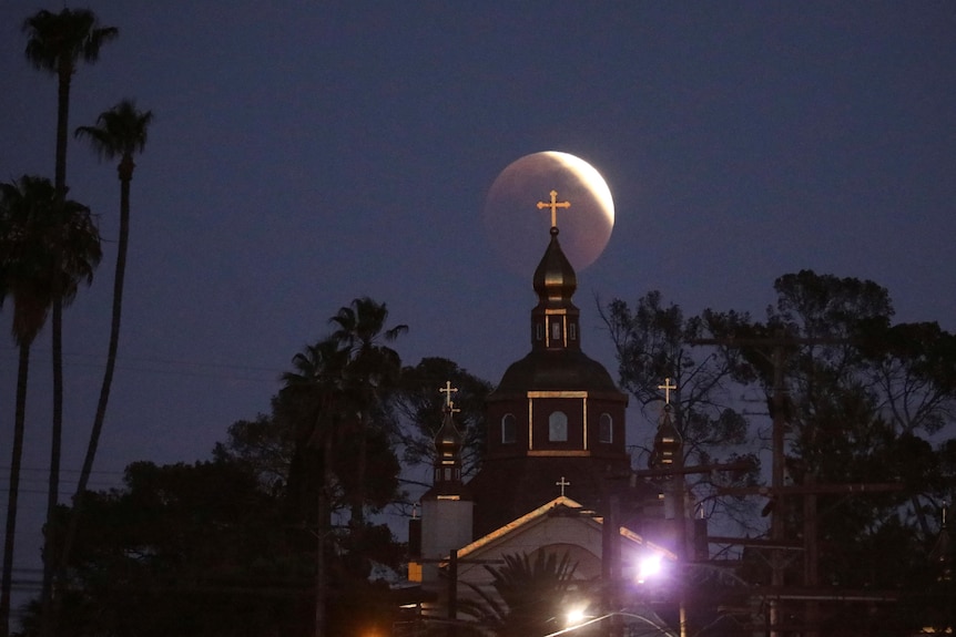 The St. Andrew's Ukrainian Orthodox Church is seen as the moon moves through the shadow of the earth.