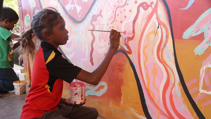 Taquisha Petrick paints an Artolution mural in Alice Springs