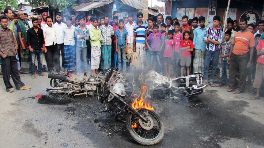 Bangladesh villagers look at a motorbike set alight during a nationwide strike by supporters of the opposition BNP.