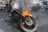 Bangladesh villagers look at a motorbike set alight during a nationwide strike by supporters of the opposition BNP.