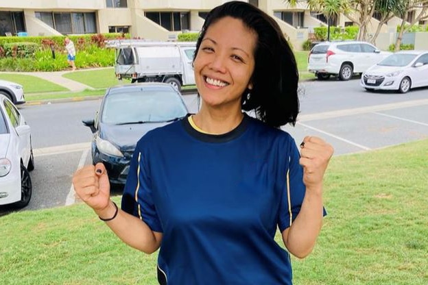 Maria Pau stands on a footpath in front of cars.