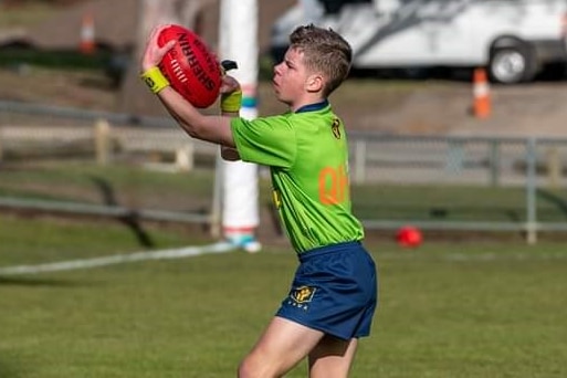 Mitchell Harwood bersiap untuk melempar bola ke dalam selama pertandingan peraturan Australia.