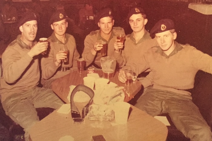 A sepia image of five soldiers drinking beer.
