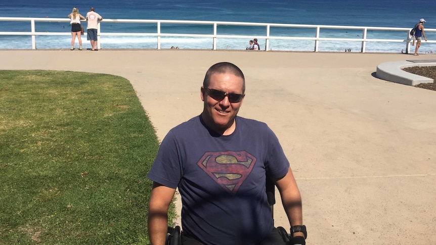 Gus McConnel sits in a wheelchair outside the beach.