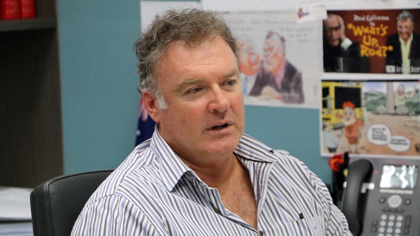 Senator Rodney Culleton at his West Perth Office, with Australian flag behind him.