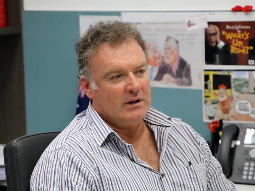 Senator Rodney Culleton at his West Perth Office, with Australian flag behind him.