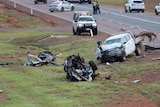 The wreckage of a vehicle and a smashed-up ute along the side of a highway