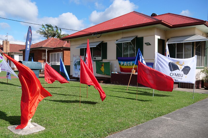 Dozens of Flags planted in front yard of house