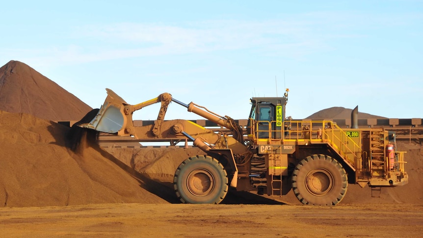 A digger moving iron ore at a Fortescue mine in the Pilbara