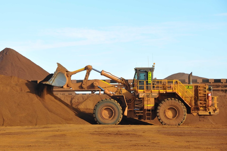 A front-end loader next to an iron ore stockpile at the Christmas Creek iron ore operations in the Pilbara region.