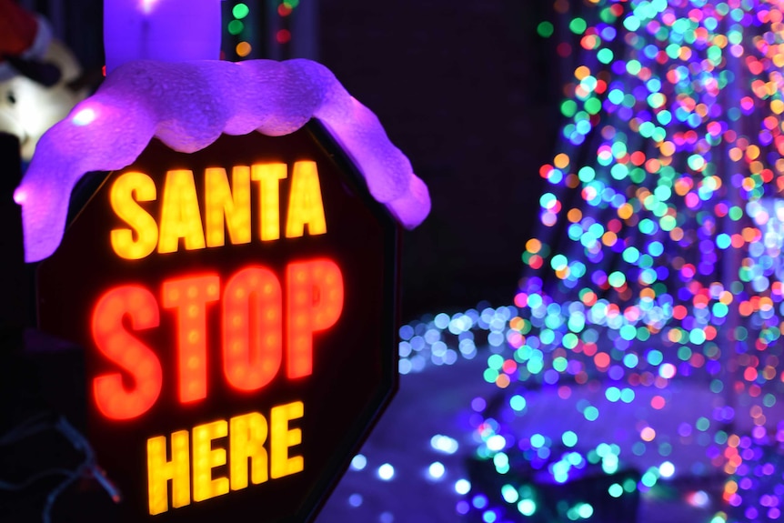 A 'Santa stop here' sign in a front yard.