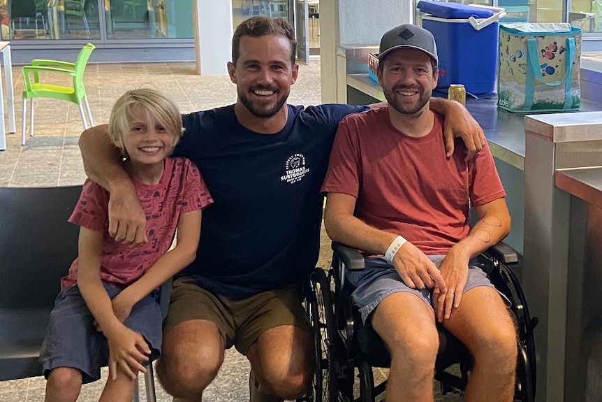 Two men and a child smiling in a hospital