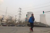 A man walks past a power plant in eastern Beijing.