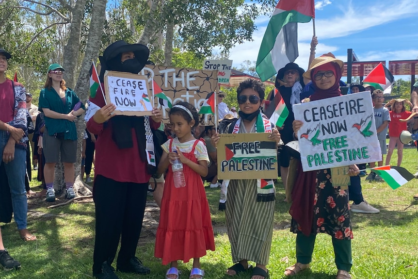 a family holds pro-palestinian placards at logan gardens in brisbane 
