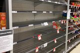 Empty supermarket shelves that were once filled with rice.