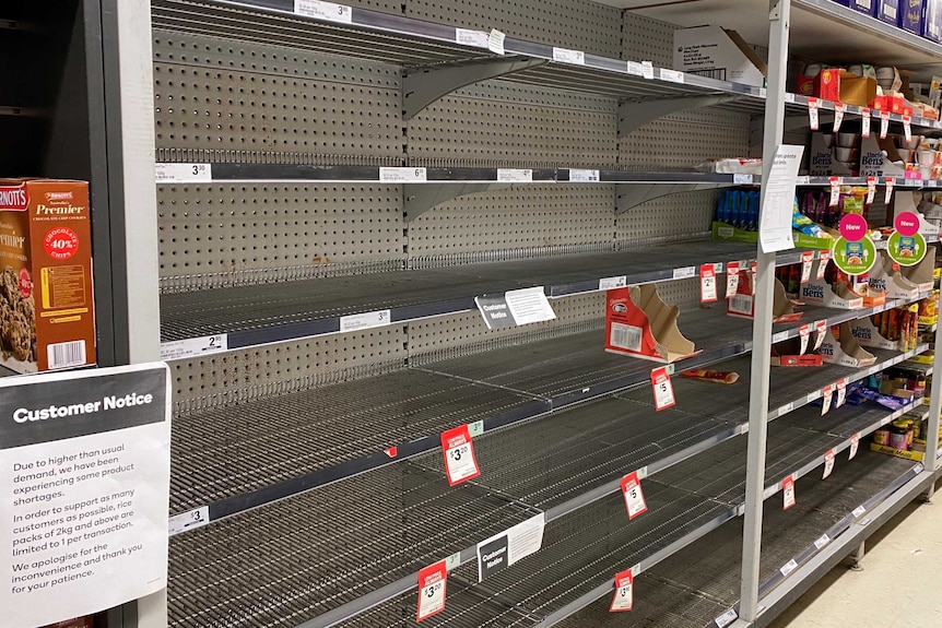 Empty supermarket shelves that were once filled with rice.