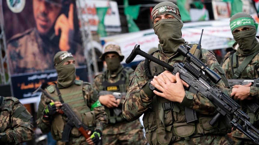 Hamas militants brandish rifles while parading through Gaza