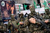 Hamas militants brandish rifles while parading through Gaza