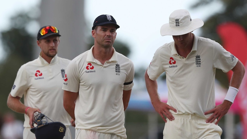 Joe Root, James Anderson, and Stuart Broad look dejected as they leave the field.