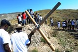 Haitians carry a cross up a hill at Titanyin on the 2nd anniversary of the 2010 earthquake.