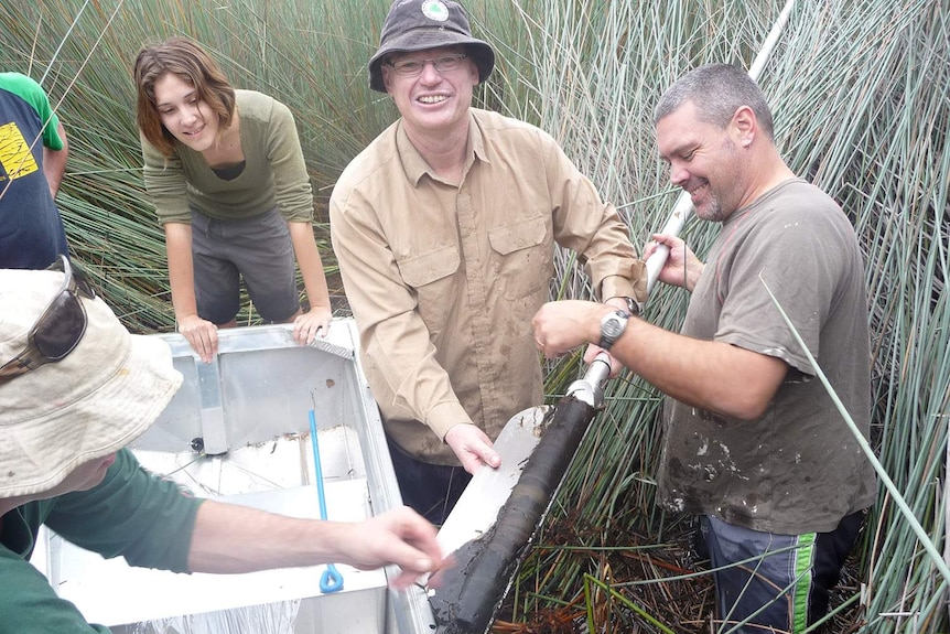 Researchers Lydia McKenzie, Jonathan Marshall and Cameron Barr take sediment core samples on North Stradbroke Island