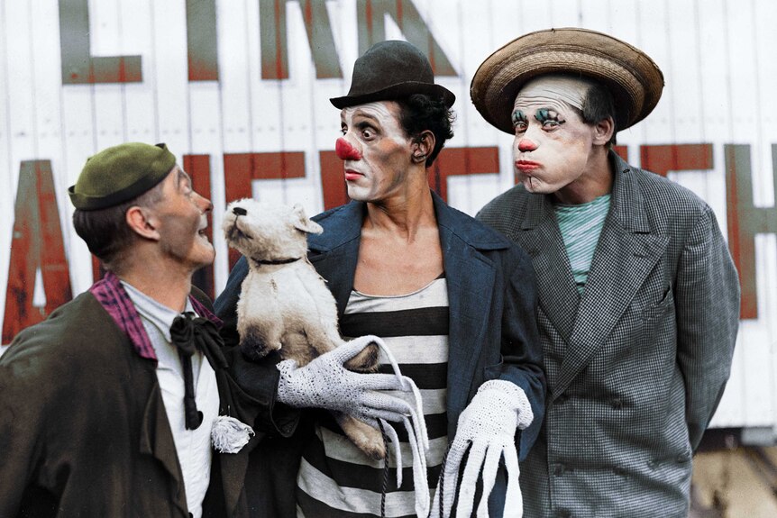 Three clowns pose for a photo.
