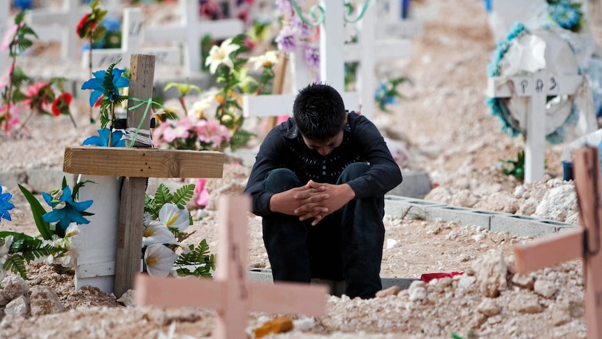 A relative of murdered teen sisters cries in the cemetery in Ciudad Juarez.