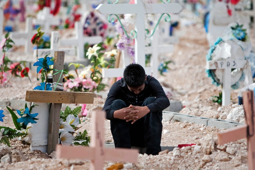 A relative of murdered sisters Griseida and Karen Barraza, cries in the cemetery in Ciudad Juarez