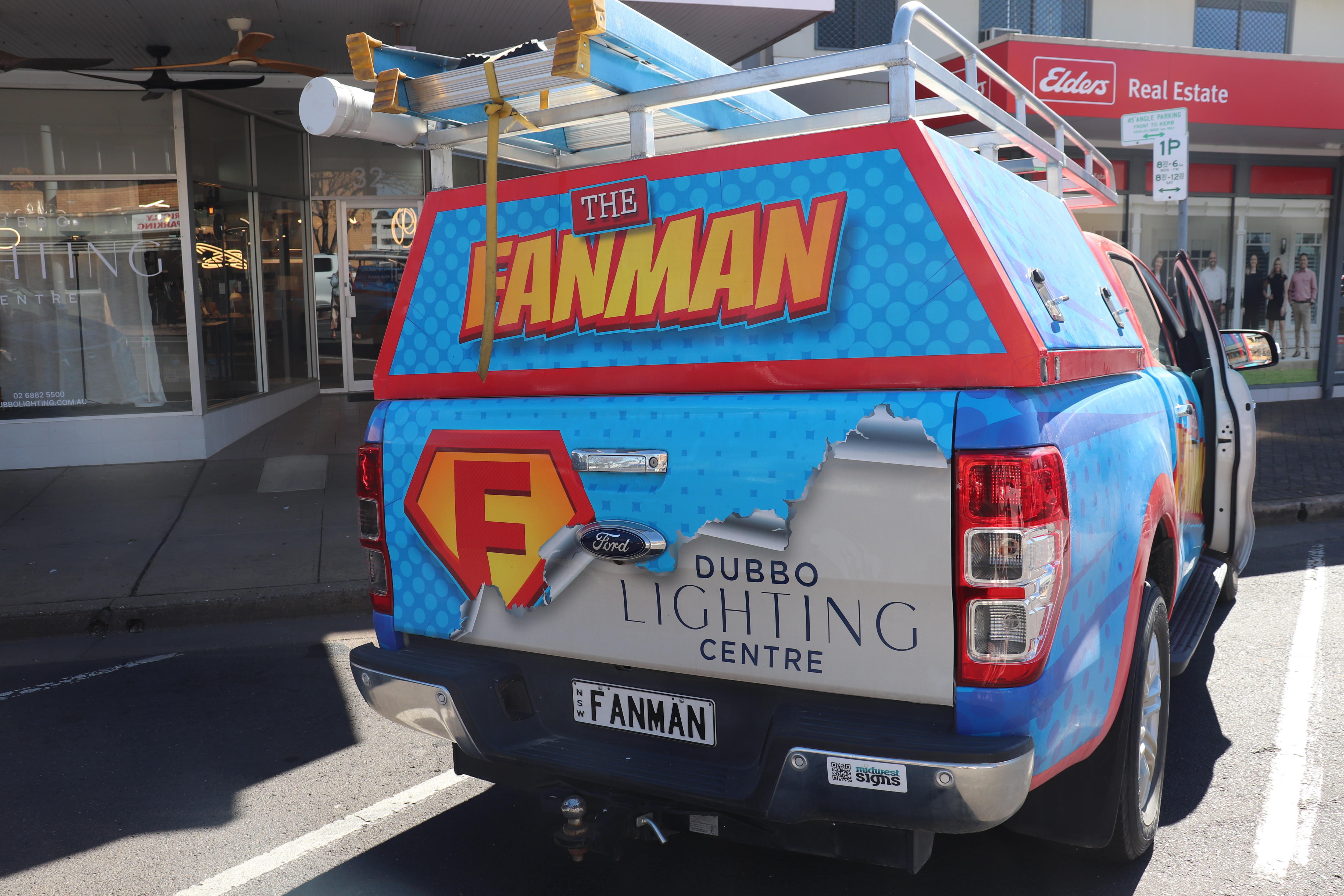 The back of a work vehicle that says "The Fanman" over the top of "Dubbo Lighting Centre".