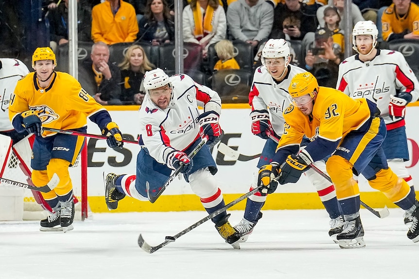 Hráč NHL sa počas hry nakloní dopredu, aby prebral loptu cez hokejku obrancu a znížil ľad do siete.
