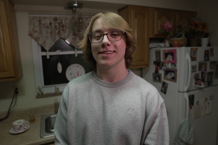 Young man standing in a kitchen.