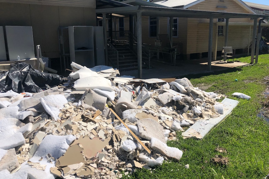 Damaged materials in front of a school after a flood.