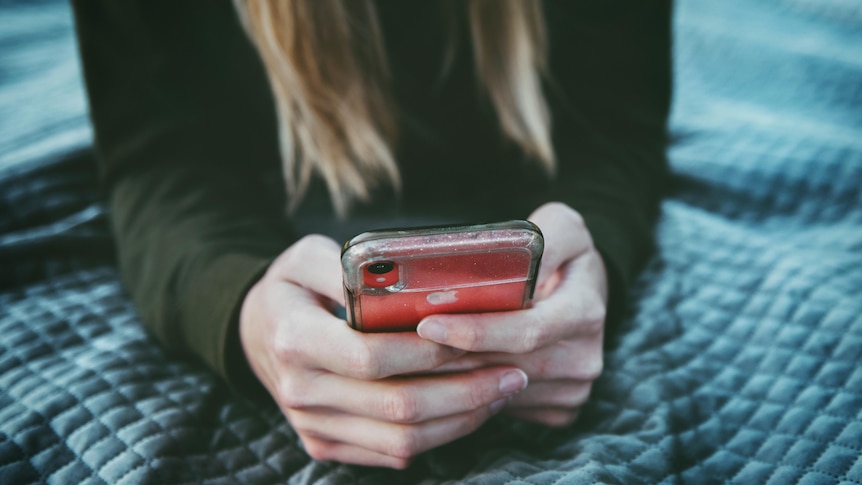 Anonymous woman with long hair holding smartphone