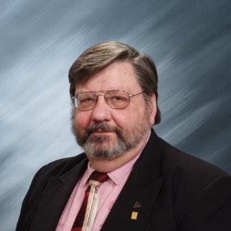 A middle-aged man in a black suit jacket.