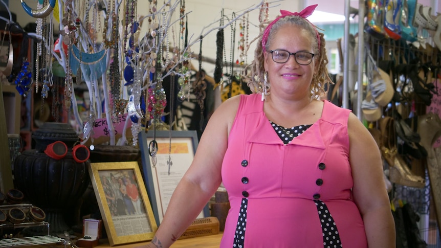 Woman in pink dress stands in a shop