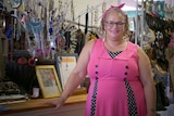 Woman in pink dress stands in a shop