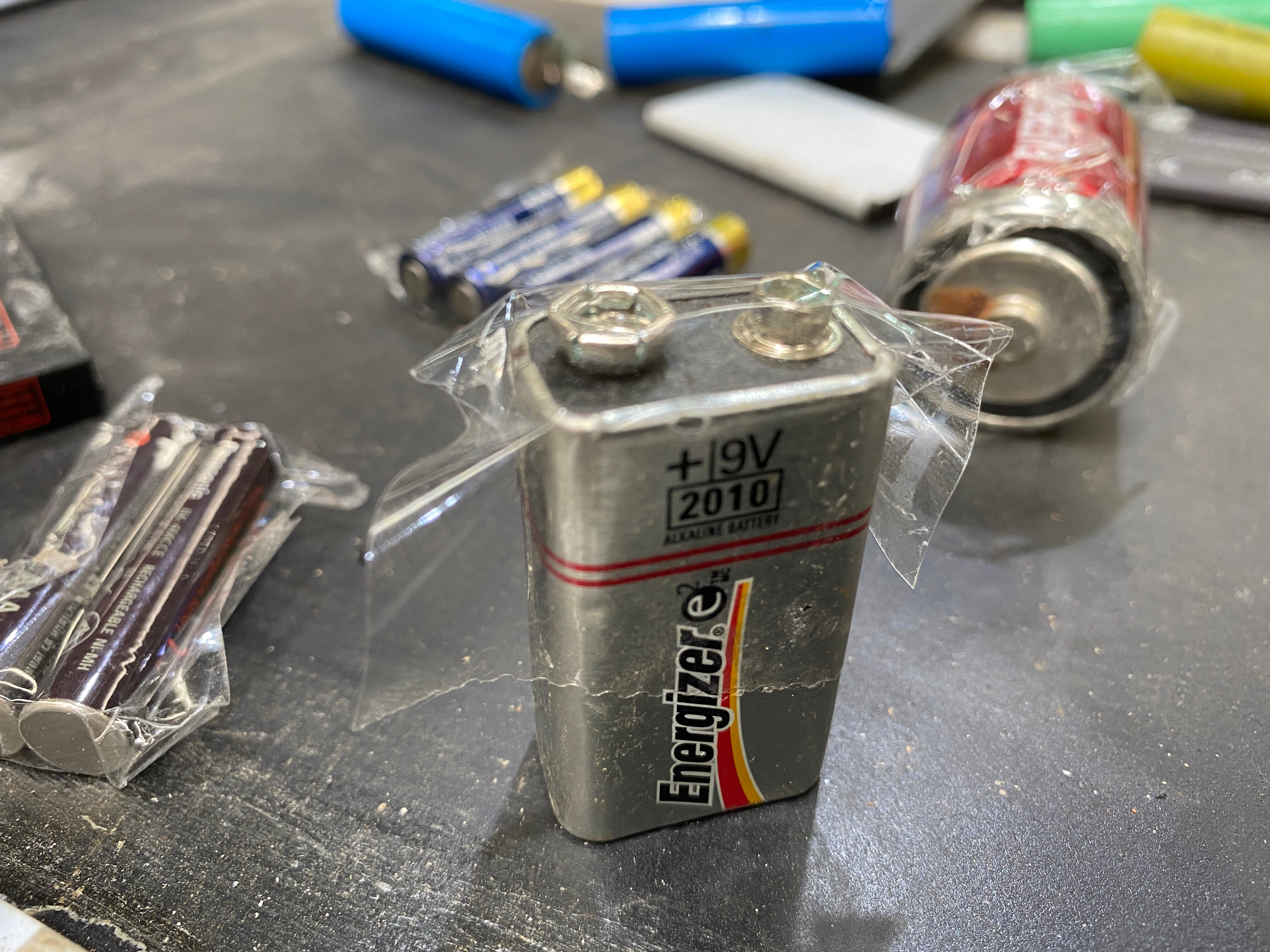 a small battery with clear sticky tape on its charging terminals