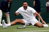 Nick Kyrgios screams in pain as he falls on the Wimbledon grass.