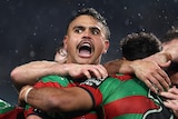 A man celebrates scoring a try in a rugby league match
