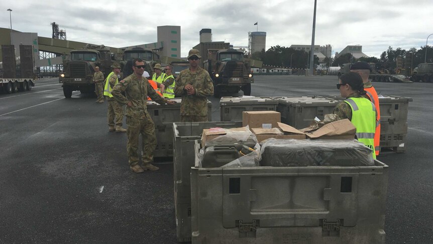 ADF workers pack emergency cyclone supplies into shipping containers.