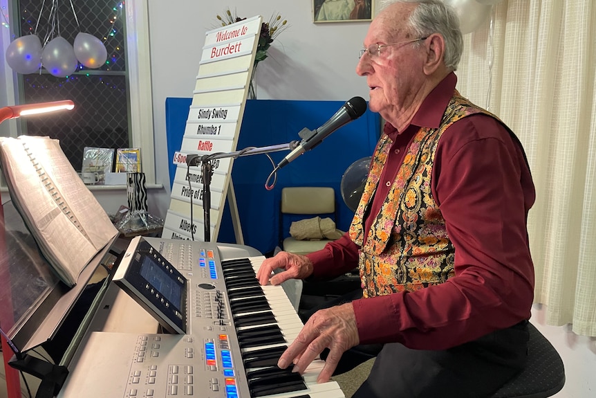 Photo of an older man playing a keyboard.