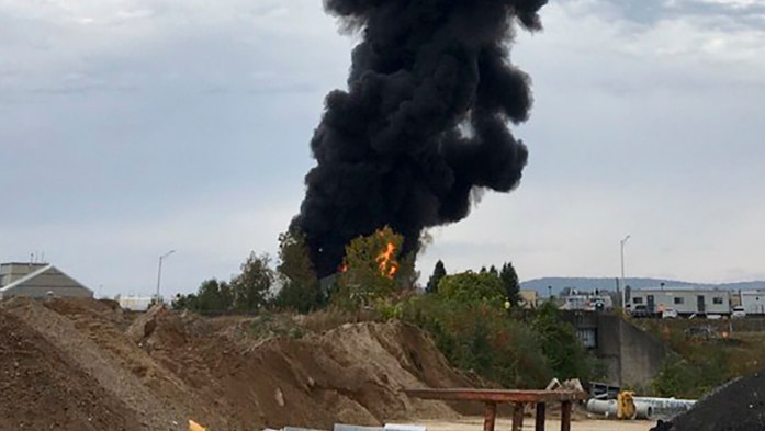 Smoke fills the sky in the moments after a WWII-era bomber plane crashed into a shed at a Connecticut airport