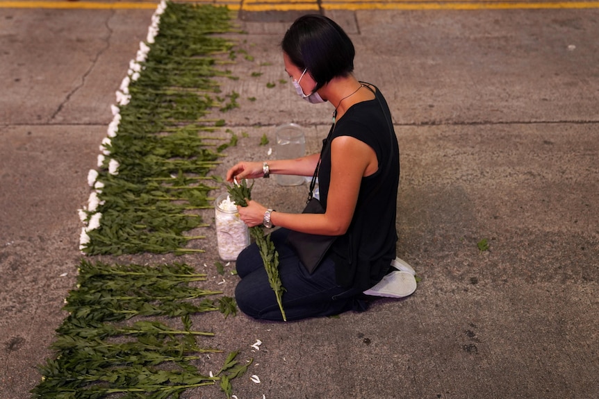 An artist lays flowers to commemorate Tiananmen Square.