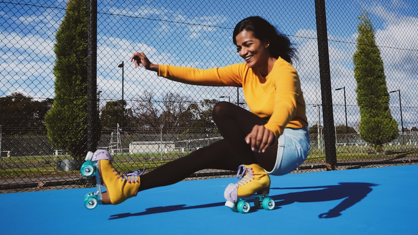 A woman roller skates with one foot off the ground for a story on roller skating helping people's health and happiness.